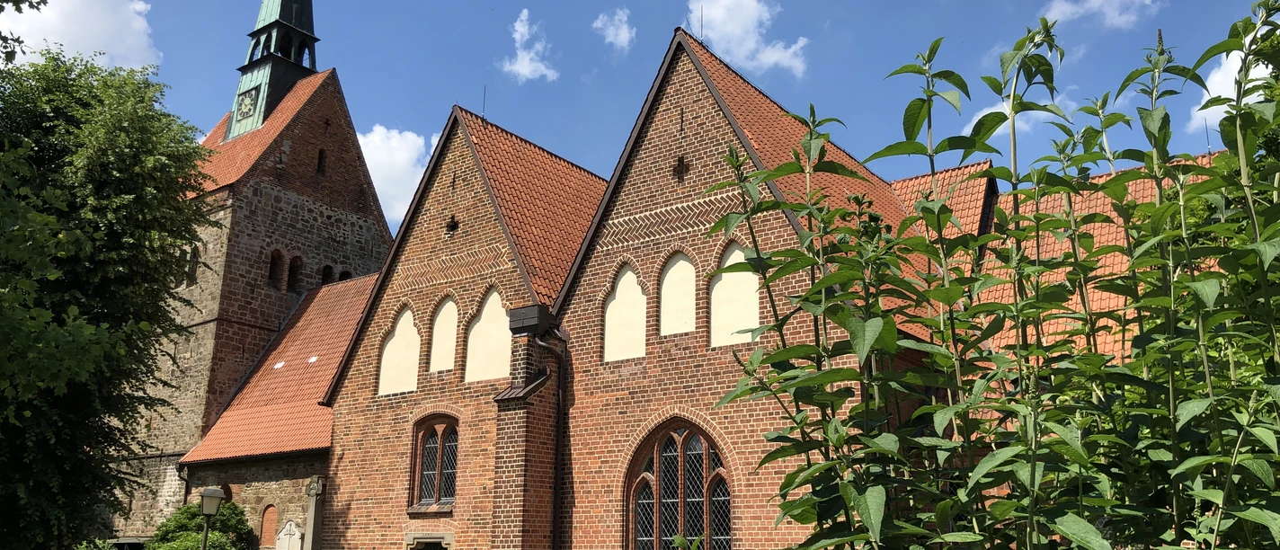 Kirche Vilsen Backsteinkirche in sommerlicher Umgebung mit Fachwerkelementen und einem markanten Kirchturm.