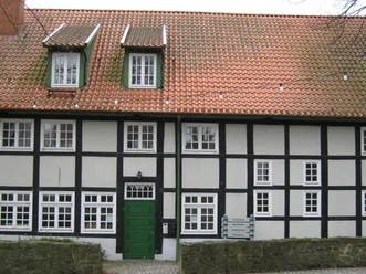 Stadtbücherei in Preußisch Oldendorf Fachwerkgebäude mit rotem Ziegeldach und grüner Tür, Stadtbücherei Preußisch Oldendorf.