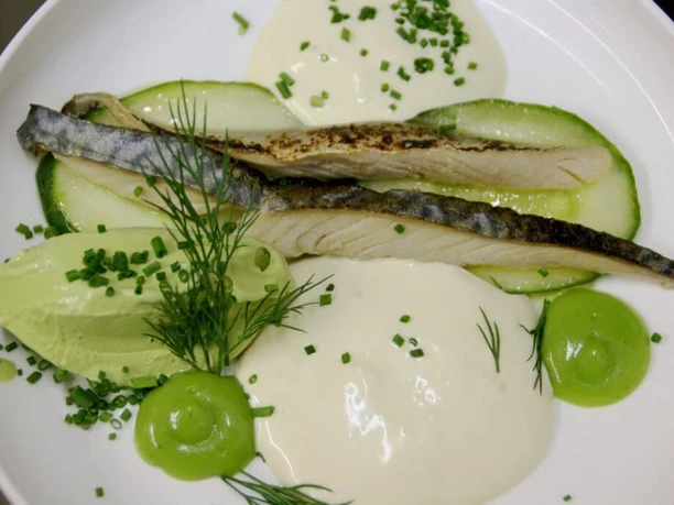 Brasserie Capricorn i Aries A fish fillet artistically arranged on a plate with various sauces.