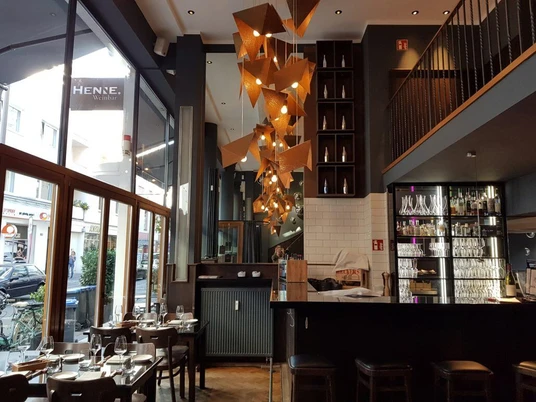 Henne Weinbar Innenansicht vom Restaurant auf eine künstlerische Hängelampe aus kupfernem Metall hergestellt.Interior view of the restaurant looking up at an artistic hanging lamp made of copper metal.