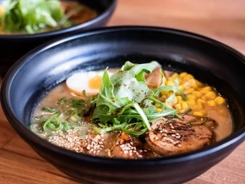 Daikan Izakaya Bar Eine Schüssel Ramen-Suppe mit Ei und Schweinefleisch.A bowl of ramen soup with egg and pork.