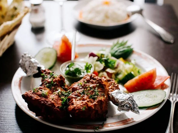 Ginti Close-up of a plate of baked chicken legs and salad.