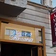 Trattoria Amalfi Außenansicht der "Trattoria Amalfi Pizzeria" mit einem auffälligen Leuchtschild und einem vertikalen Banner an der Wand.Exterior view of "Trattoria Amalfi Pizzeria" featuring a striking illuminated sign and a vertical banner attached to the wall.