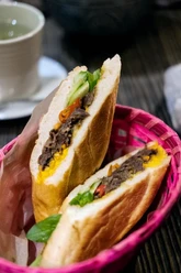 Cafe 1980 Bunt gefülltes Baguette-Sandwich mit frischem Gemüse in einem pinken Korb.