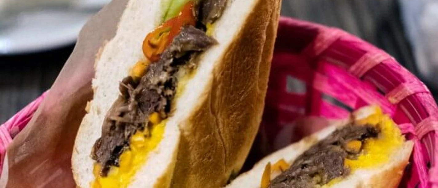 Cafe 1980 Bunt gefülltes Baguette-Sandwich mit frischem Gemüse in einem pinken Korb.