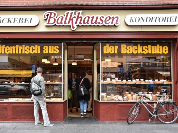 Bakery Balkhausen Exterior view of the bakery. A man looks at the shop window filled with baked goods.