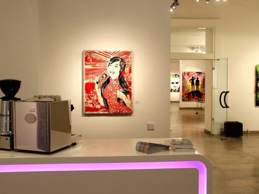 30work Galerie Innenansicht der 30works Galerie in Köln: Kunstwerke von mittenimwald und EMESS an den Wänden auf weißem Hintergrund, zentral ein Kunstwerk in Rottönen, Kontraste mit schlichter Möblierung.Interior view of the 30works gallery in Cologne: artworks by mittenimwald and EMESS displayed on white walls, centrally featuring a piece dominated by shades of red, contrasted by minimalist furnishings.