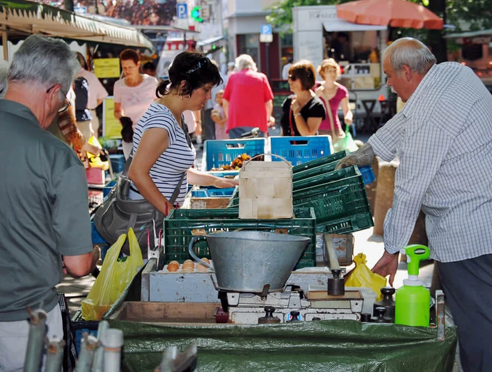 Wochenmarkt in Deutz Marktszene mit Menschen, die frisches Obst und Gemüse an einem Kölner Stand begutachten und einkaufen.Market scene with people inspecting and buying fresh fruit and vegetables at a stall in Cologne.
