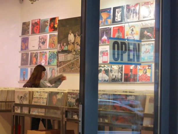 Parallel Schallplatten A record store with open doors shows a person browsing through records inside.