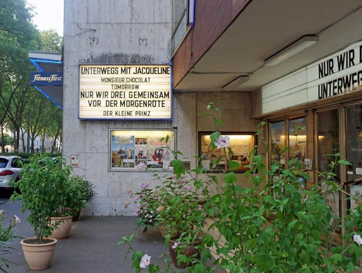 Weisshauskino Eingangsbereich des Weisshauskinos mit Leuchtreklame und PflanzenEntrance area of the Weisshaus cinema with neon sign and plants