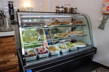Cafe Frau Maaß Herr Schlie Glasvitrine mit herzhaften Quiche und Salaten.