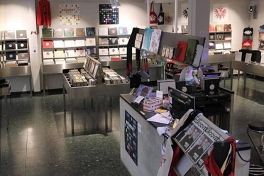 Kompakt Im Laden „Kompakt“ in Köln stehen verschiedene Regale mit Schallplatten und CDs; ein einladendes Ambiente für Musikliebhaber*innen.