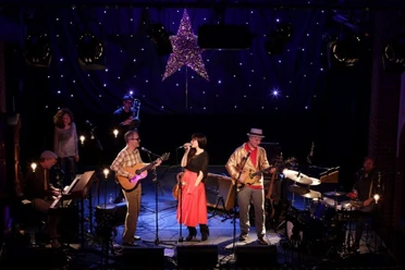 Kulturkirche Band Erdmoebel bei Konzert in der Kulturkirche Köln, Bühne festlich beleuchtet mit Stern.