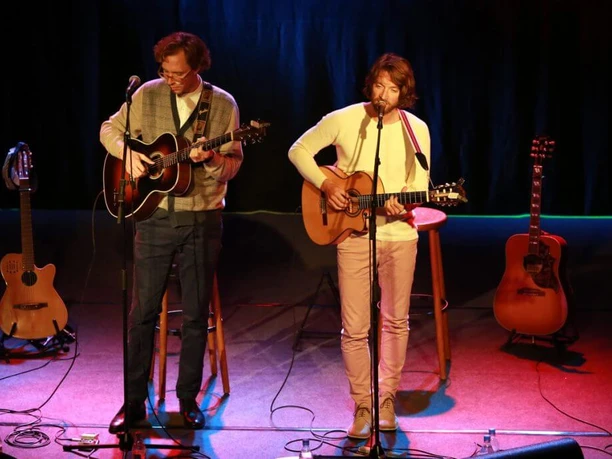 Kulturkirche Ein Duo spielt akustische Gitarren auf einer atmosphärisch beleuchteten Bühne.