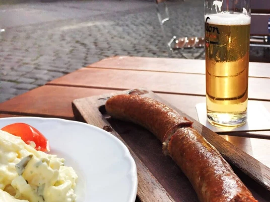 Brewery Sion Bratwurst, Kartoffelsalat und Sion Kölsch mit Blick auf die Altstadt.Bratwurst, potato salad and Sion Kölsch with a view of the old town.