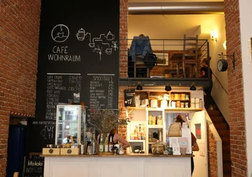 Wohnraum Café mit Ziegelwänden, Kreidetafel-Menüs und einladendem Ambiente im Wohnraum-Stil.