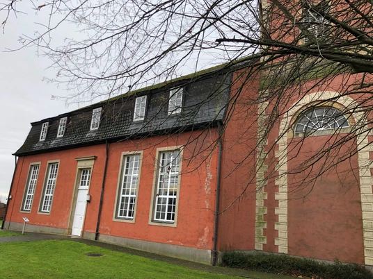Kirche Intschede Langhaus Backsteinkirche in Intschede mit großen weißen Fenstern und einer Backsteinfassade an trübem Tag.