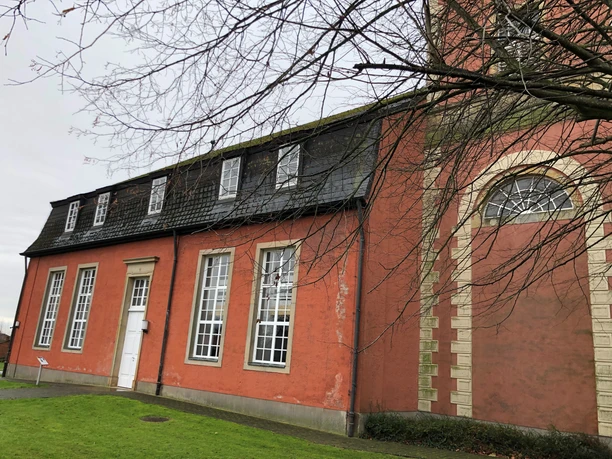 Kirche Intschede Langhaus Backsteinkirche in Intschede mit großen weißen Fenstern und einer Backsteinfassade an trübem Tag.