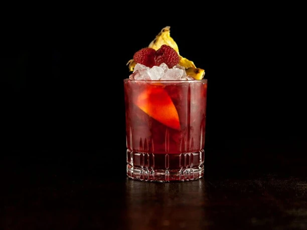 Bar Little Link A red cocktail elegantly presented against a black background.