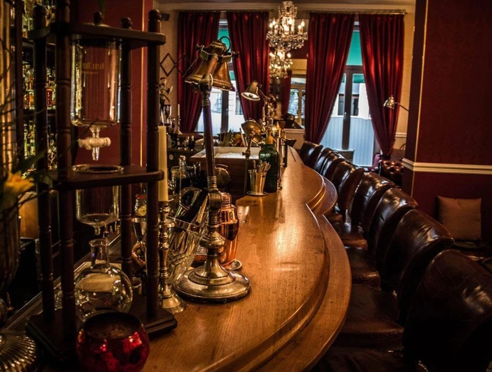 Seiberts Cocktailbar Eine gemütliche Cocktailbar mit einer eleganten Holztheke, umgeben von Lampen und Sitzgelegenheiten. Die Atmosphäre ist einladend und stilvoll.A cozy cocktail bar featuring an elegant wooden counter, surrounded by lamps and seating areas. The atmosphere is inviting and stylish.