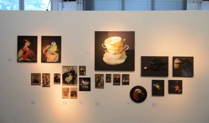 artrmx e. V. | Atelierzentrum Ehrenfeld Verschiedene Kunstwerke hängen leicht ungleichmäßig an einer weißen Wand in einer Galerie.