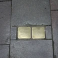 Stolpersteine Zwei Messingplatten inmitten von Bürgersteigpflaster gedenken Opfern des Nationalsozialismus.