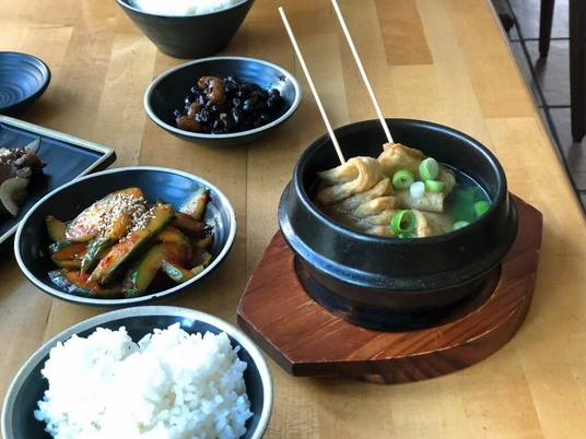 Restaurant Anju, Tapas Koreanische Speisen in kleinen Schüsseln, Gurkensalat, Reise und Teigtaschen.Korean dishes in small bowls, cucumber salad, rice and dumplings.