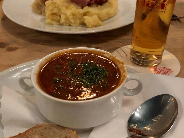 Pütz Brewery Ein köstliches Gericht aus herzhaftem Gulasch und Brot, begleitet von einem erfrischenden Bier.A delicious dish of hearty goulash and bread, accompanied by a refreshing beer.