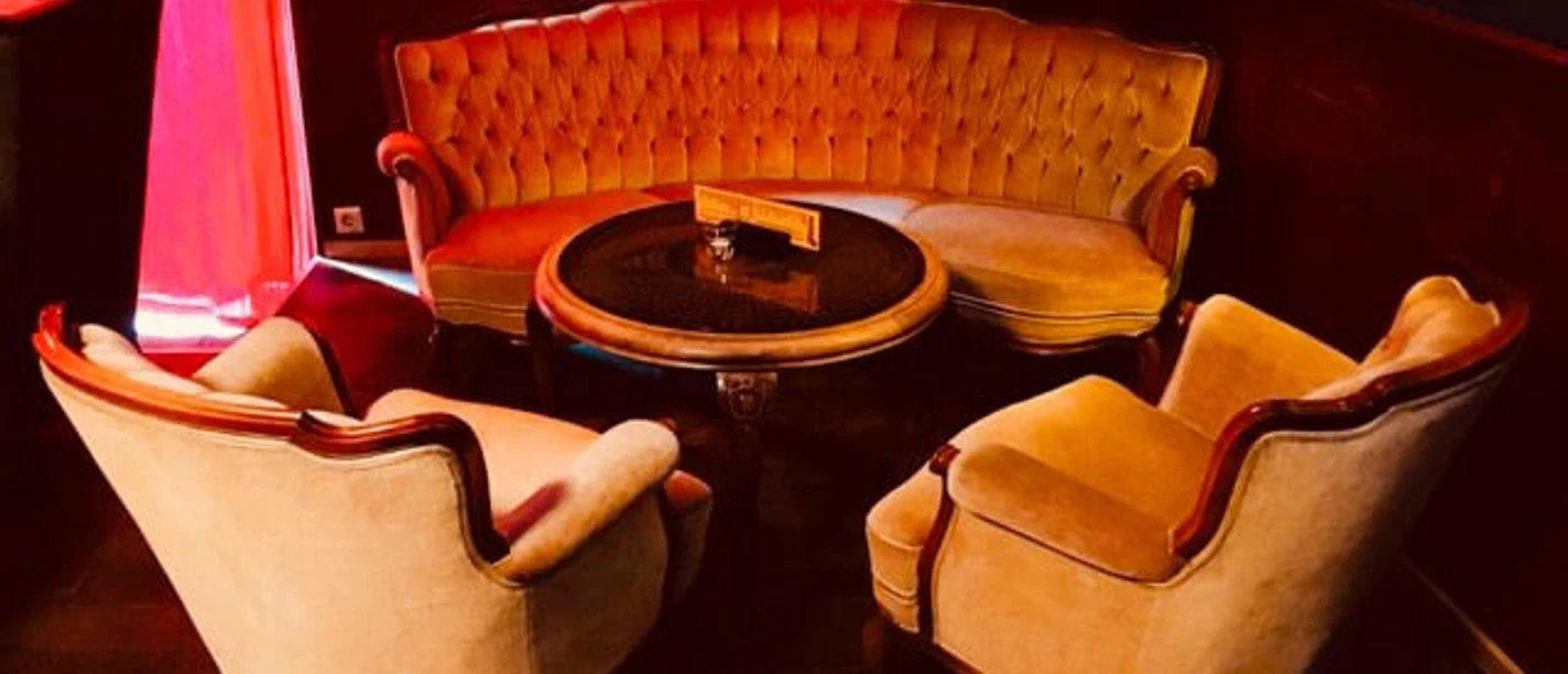 Die hängenden Gärten von Ehrenfeld Bar Seating area with armchairs and coffee table in 50s style.