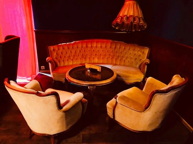 Die hängenden Gärten von Ehrenfeld Bar Sitzecke mit Sesseln und Couchtisch im 50er Jahre Stil.Seating area with armchairs and coffee table in 50s style.