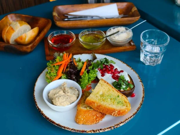 Cafe Jealys Close-up of a white plate with delicious food on a blue table.