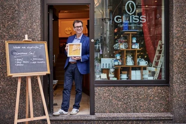 Michael Glisss A man stands with an award in front of the "GLISS" café