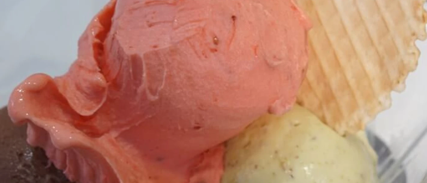 IL GELATO di ferigo Close-up of three scoops of ice cream with a round cone.