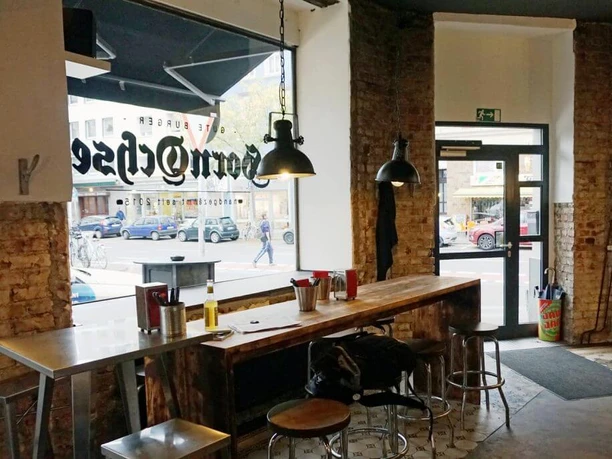 Burger Restaurant Hornochse Im industriellen Stil eingerichtetes Restaurant mit Backsteinwand und metallischen Hängeleuchten.