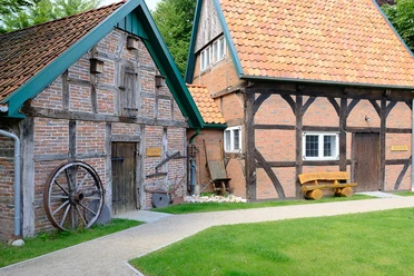 DSCF1618_klein.jpg Altes Bauernhaus mit Fachwerk, Holztür und grünem Gartenweg.