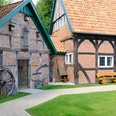 DSCF1618_klein.jpg Altes Bauernhaus mit Fachwerk, Holztür und grünem Gartenweg.