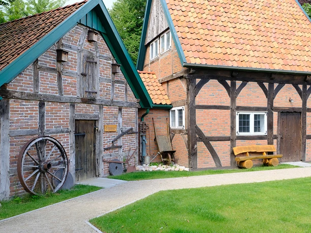 DSCF1618_klein.jpg Altes Bauernhaus mit Fachwerk, Holztür und grünem Gartenweg.