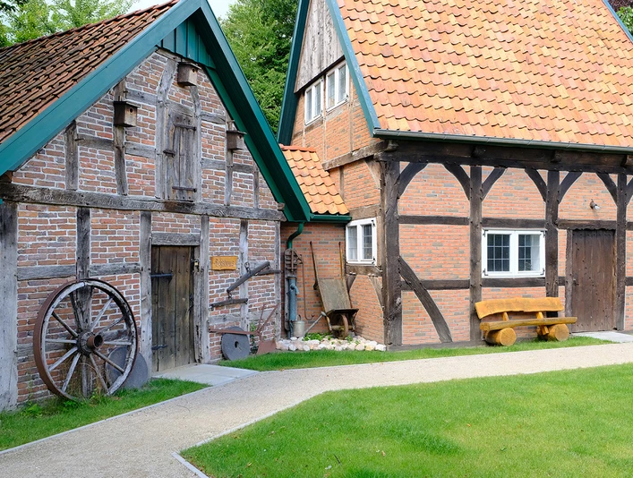 DSCF1618_klein.jpg Altes Bauernhaus mit Fachwerk, Holztür und grünem Gartenweg.