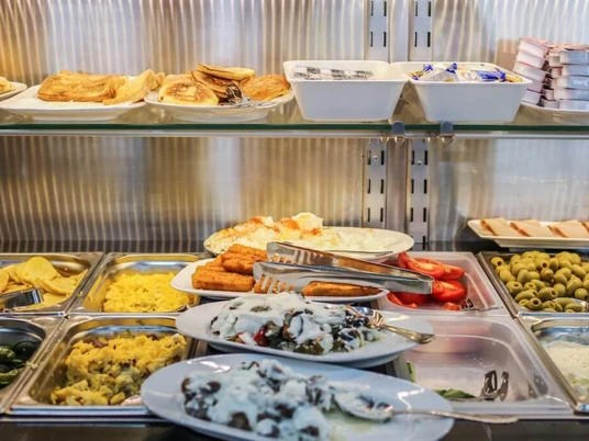 Simitzade Buffet mit verschiedenen Frühstücksspezialitäten, darunter Pancakes, Oliven und Joghurtgerichte.Buffet featuring various breakfast specialties, including pancakes, olives, and yogurt dishes.