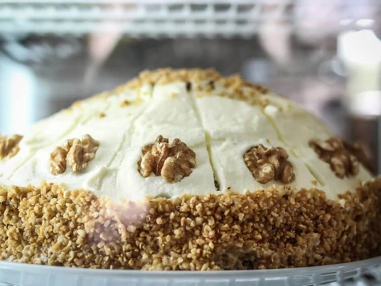 KAFFEEBUD Nahaufnahme einer Torte mit Walnuss.Closeup of a pie with a walnut on top.