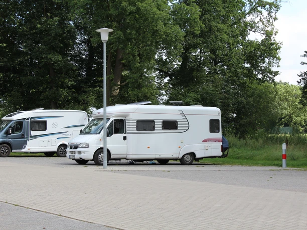 RV campgrounds are located on paved sites against a backdrop of green woods in Steimbke.