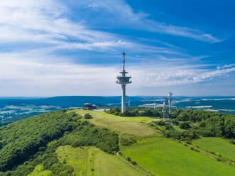 Luftaufnahme des Köterbergs mit Funkturm und weitem Blick über grüne Landschaft und blauen Himmel.