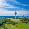 Luftaufnahme des Köterbergs mit Funkturm und weitem Blick über grüne Landschaft und blauen Himmel.