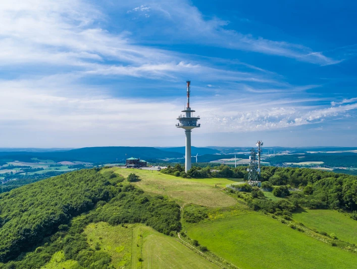 Luftaufnahme des Köterbergs mit Funkturm und weitem Blick über grüne Landschaft und blauen Himmel.