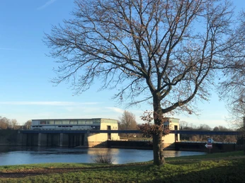 Wehr Schlüsselburg Wehr Schlüsselburg im goldenen Herbstlicht, Baum im Vordergrund, klare Strukturen und blauer Himmel.
