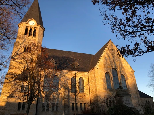 Kirche Frille Eine historische Kirche mit markantem Turm leuchtet im warmen Licht der Abendsonne.