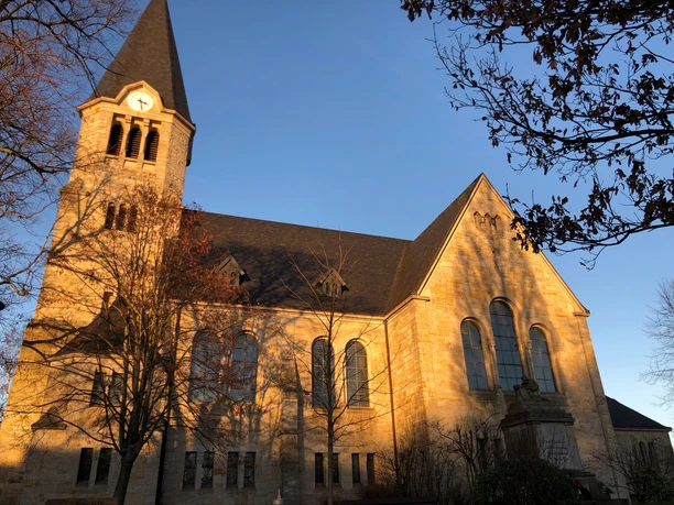Kirche Frille Eine historische Kirche mit markantem Turm leuchtet im warmen Licht der Abendsonne.