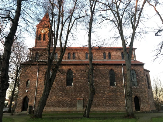 Kirche Friedewalde Backsteinkirche aus dem 13. Jahrhundert mit hohen Fenstern und mittelalterlichem Turm, umgeben von Bäumen.
