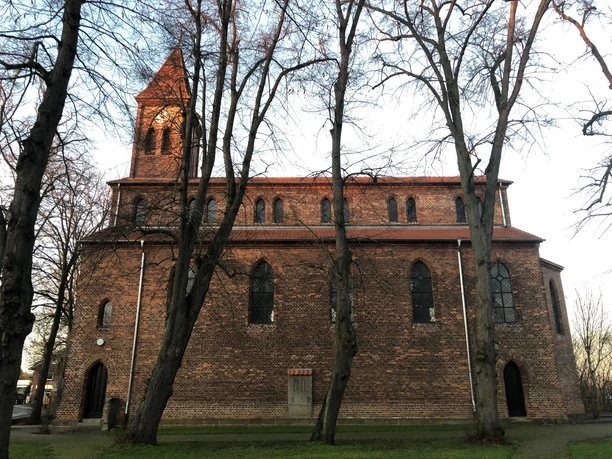 Kirche Friedewalde Backsteinkirche aus dem 13. Jahrhundert mit hohen Fenstern und mittelalterlichem Turm, umgeben von Bäumen.