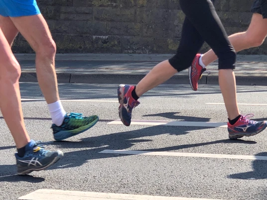 Spargellauf Nienburg Gruppe von Läufern in sportlichen Schuhen auf einer Stadtstraße beim Spargellauf Nienburg.